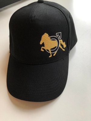 Zoom bild av keps,keps med klubblogga,killar som rider islandshäst